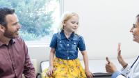 Father and young daughter talk with Radiologist about upcoming EOS exam.